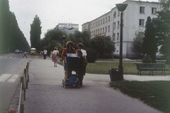 Kobiety z wózkiem dziecięcym na chodniku. W tle Kombinat Cementowy 