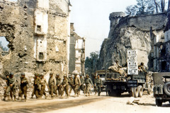 United States Army camions et jeeps conduisent dans les ruines de Saint-Lo