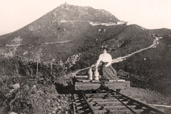 Woman with milk cans on the West Peak radio Station Incline