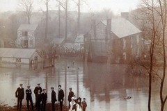People posing for a photo near the Crooked House pub during a flood