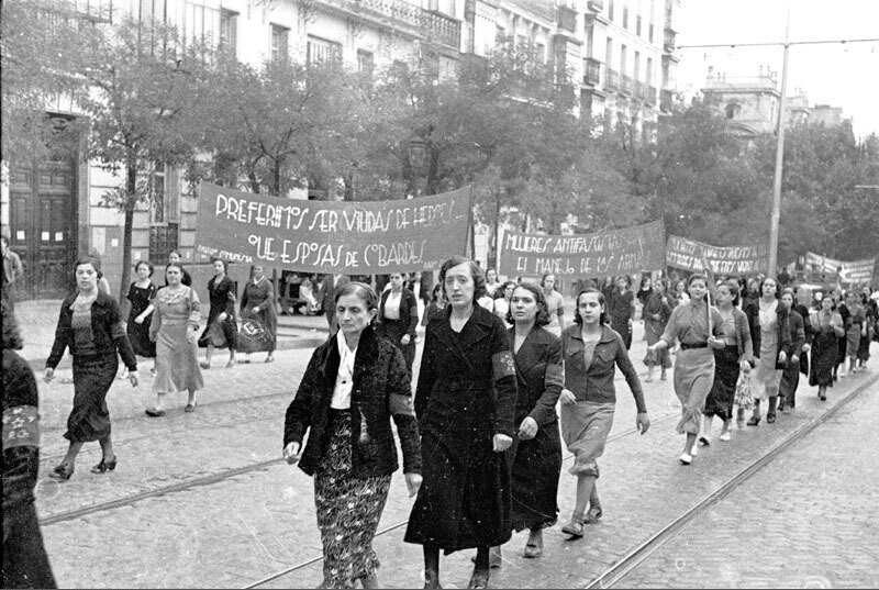 Manifestación en la calle Génova, En primer lugar mujeres portando la pancarta con el lema preferimos ser viudas de héro