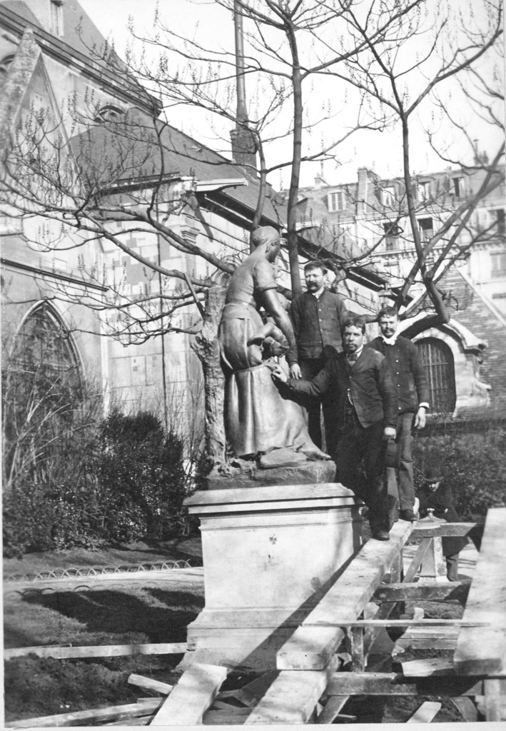 Trois hommes près d'une statue en ronde-bosse dans le square de l'église Saint-Médard