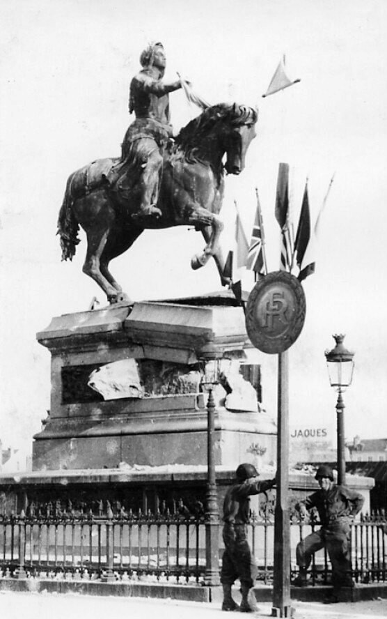 Deux soldtas américains posant devant la statue de Jeanne d'Arc endommagée
