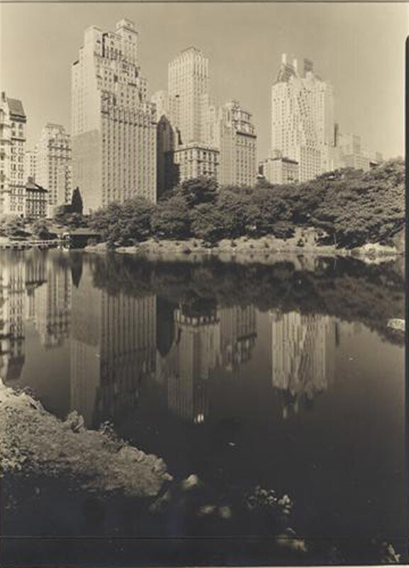 New York City views. St. Moritz Hotel and others, reflected in lake,