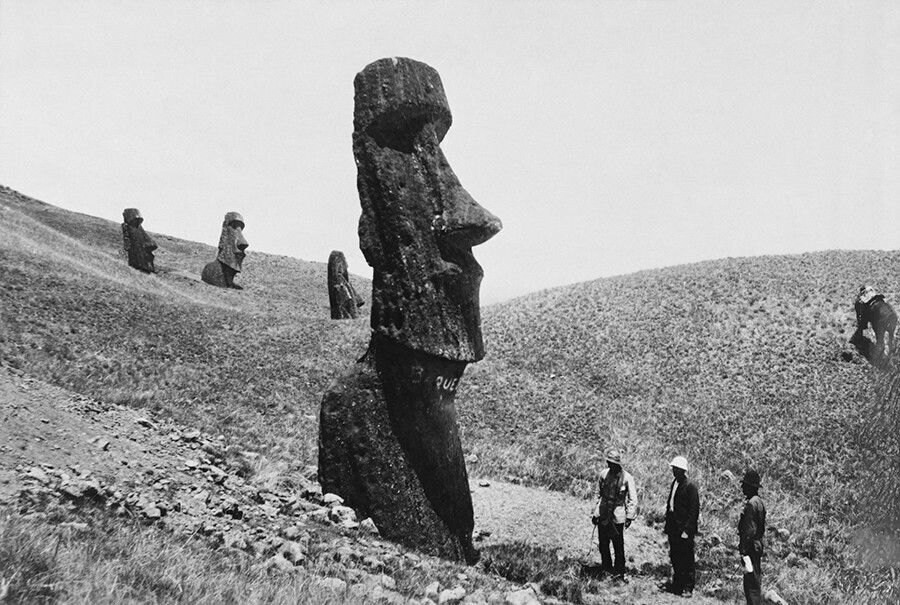Los hombres observan las estatuas gigantes de la Isla de Pascua en Polinesia