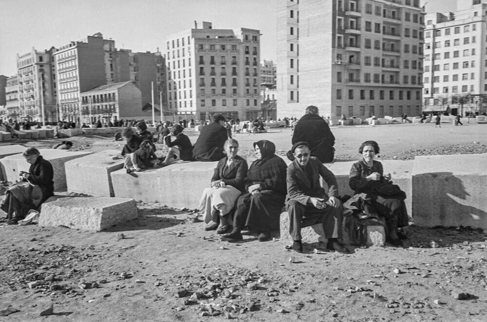 Grupo de personas sentadas en bloques de piedra en una zona en reconstrucción