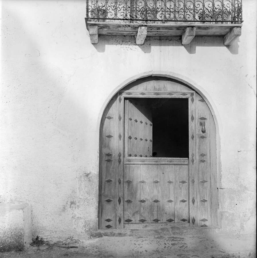Puerta de madera y balcón de forja en Sigüés