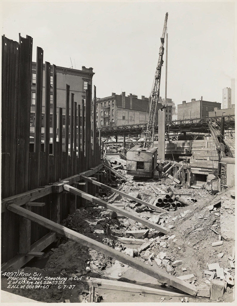 Placing steel sheathing in cut, east of Sixth Avenue between West 52nd Street and West 53rd Street, E.N.L. at