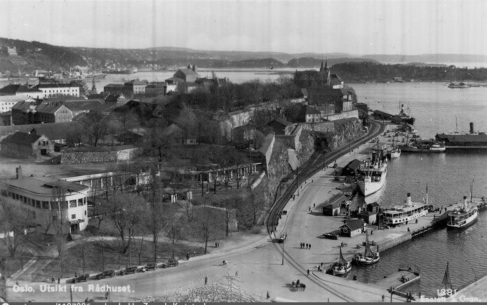 Utsikt fra Oslo rådhus over Akershus festning, med Skansen restaurant og havnebanen langs Pipervika