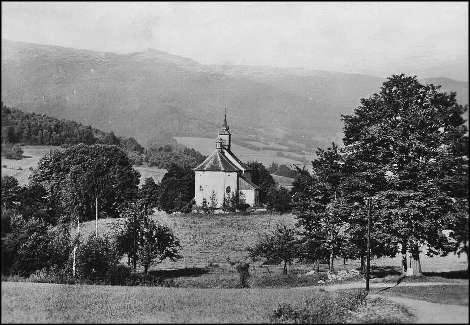 Zelená Lhota. Kostel sv. Volfganga a v pozadí hora Ostrý
