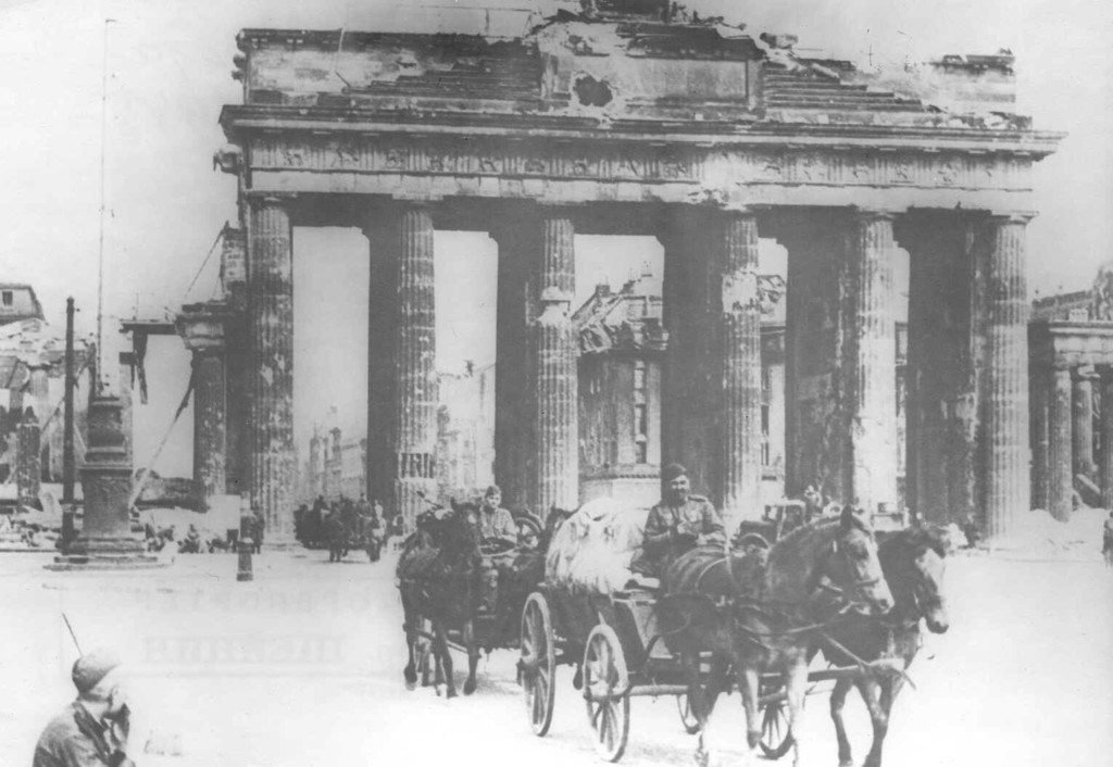 Sowjetische Soldaten auf berittenen Karren fahren am Brandenburger Tor in Berlin vorbei