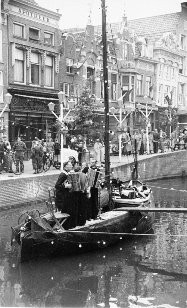 Alkmaar. Volendammer straatmuziekanten op een bootje in het water van de Mient