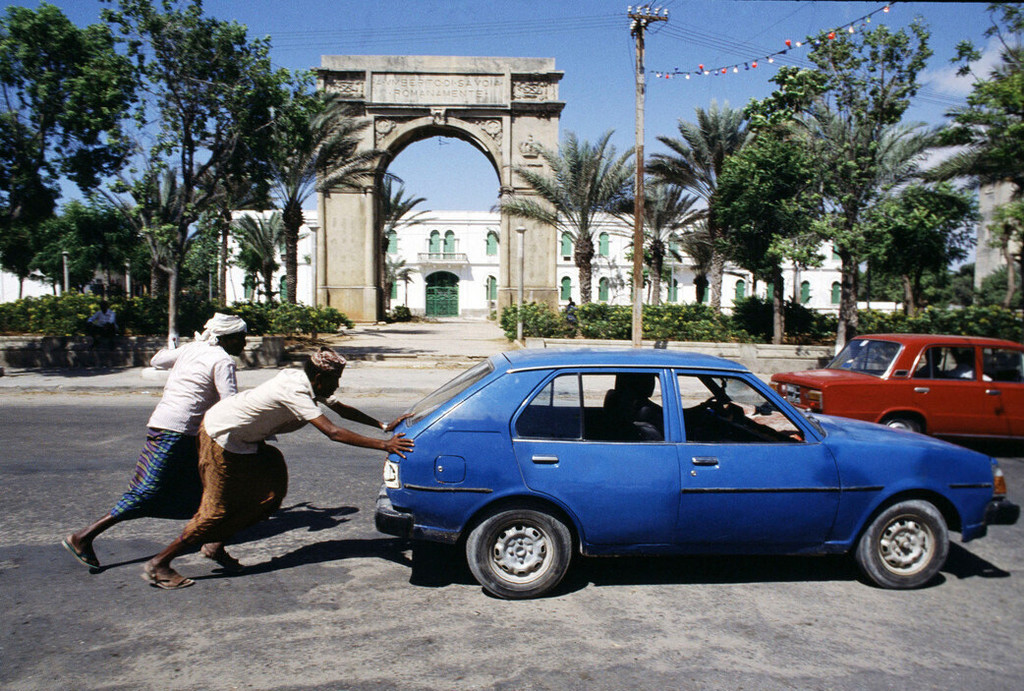 Mogadishu, Somalia. Two men pushing a car on the street Corsa Somalia