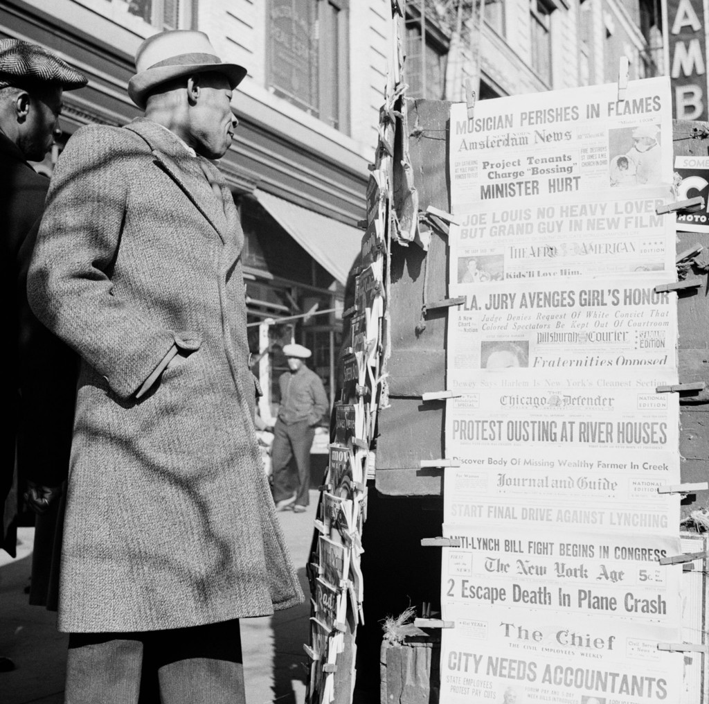 Man passing newspaper stand