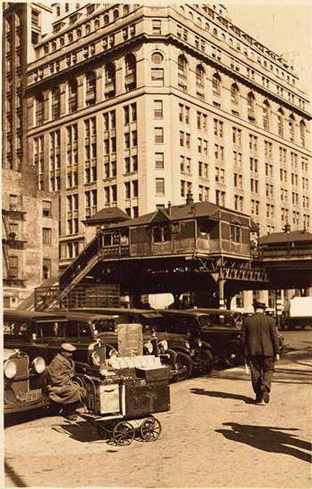 A peanut vendor on the north side of Battery Park and showing also cars on Battery Place