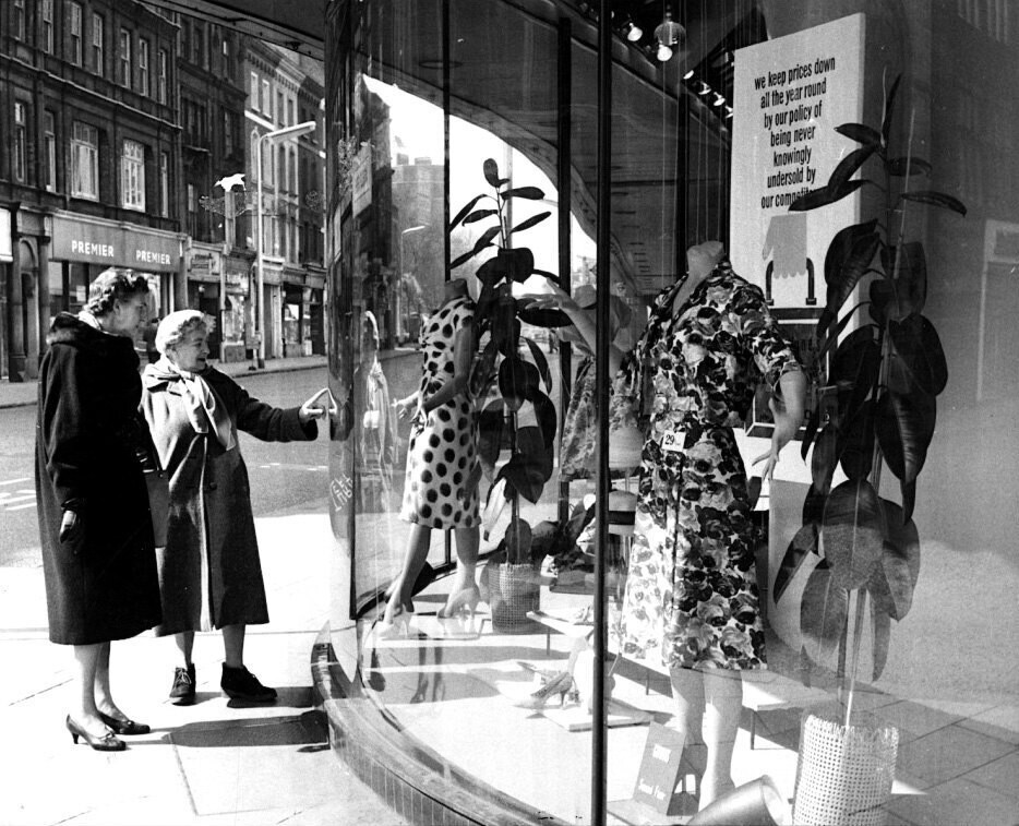 A pair of women look into a window at the Peter Jones
