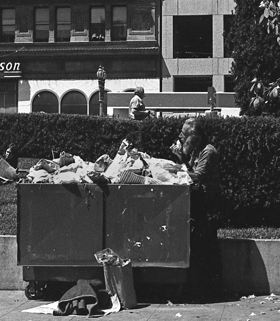Homeless man eats from trash bin in Union Square
