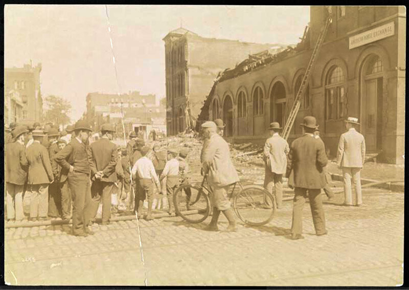 Men and boys in the street observing the ruins of the American Horse Exchange