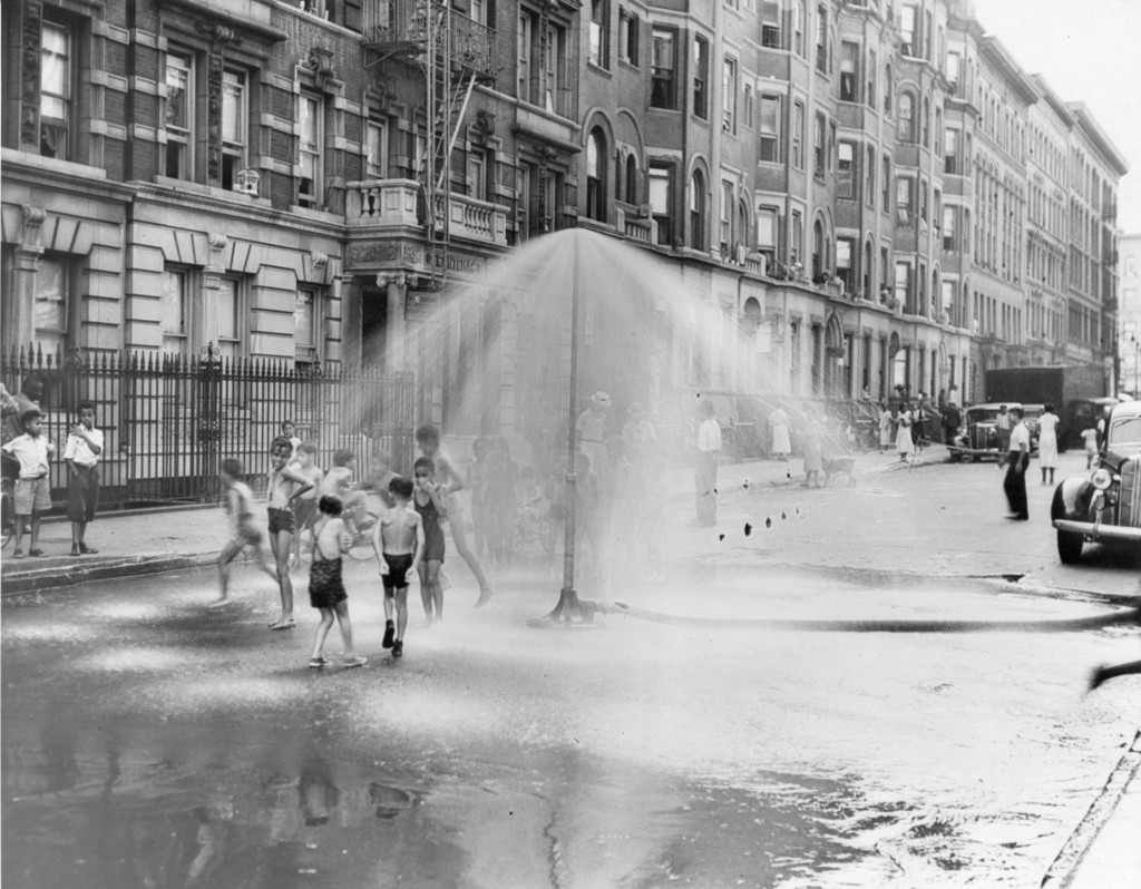 Children play in a sprinkler from a water hydrant in South Harlem