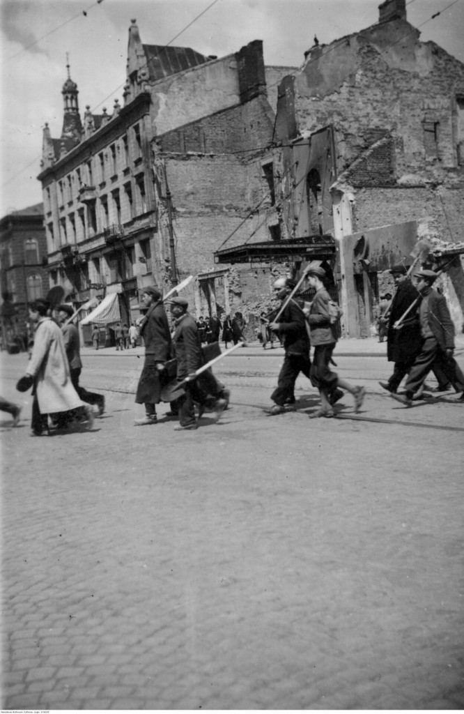 Grupa Żydów z łopatami na ramionach w drodze do miejsca pracy w drodze przez ul. Marszałkowską