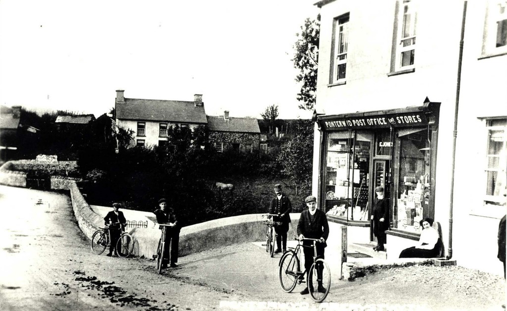 Postman and locals with their bikes outside Ponterwid post office and stores