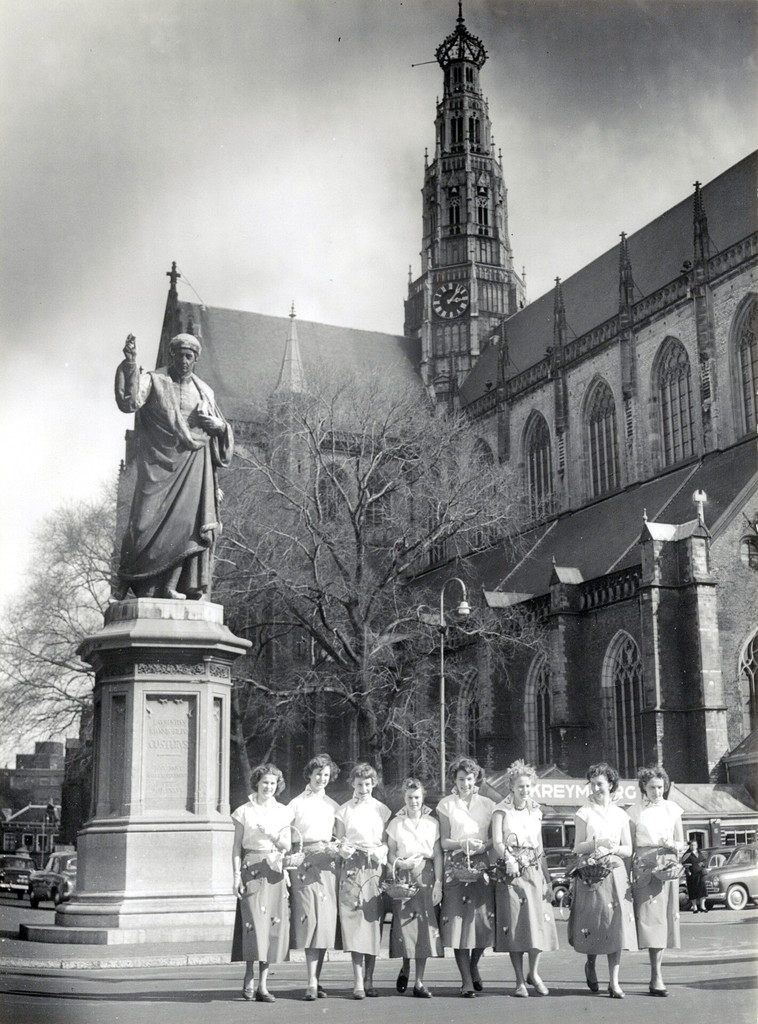 Haarlem. De Haarlemse bloemenmeisjes voor het standbeeld van L.J. Coster en de Grote Kerk