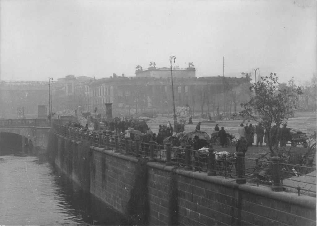 Deutsche Zivilisten auf der Böschung nahe Schlossplatz in Berlin