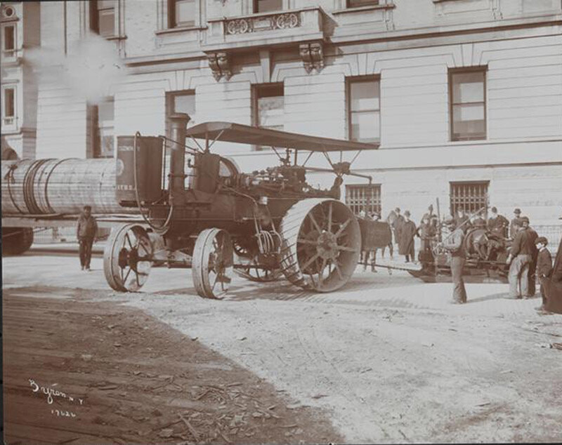 Steam-powered tractor pulling a large stone column