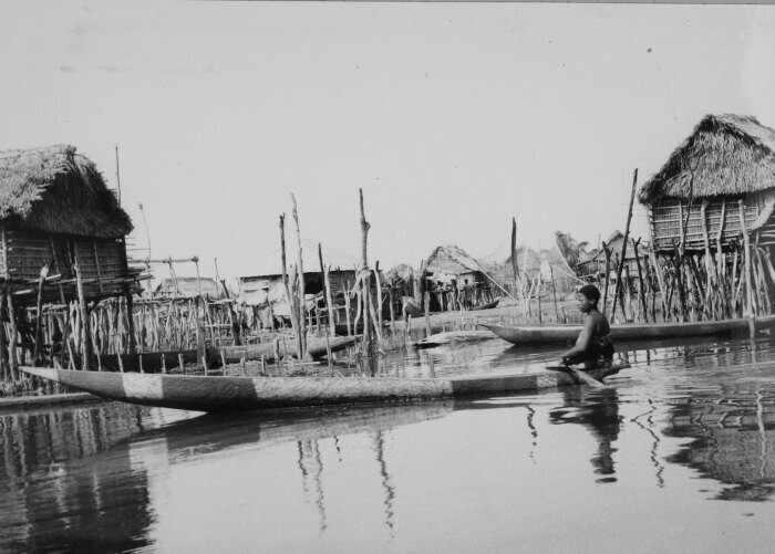 Woman in a canoe in the lake settlement Ganve