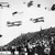 6 biplanes and 1 airship over crowd