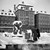 Snöröjning på Skeppsbron. Två män skottar snö på Skeppsbrokajen vid Sjöguden av Carl Milles